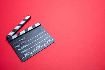 Movie clapperboard on red color background, copy space