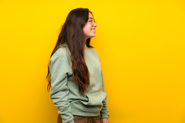Teenager girl with sweatshirt standing and looking to the side