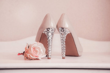 Wedding shoes pink high-heeled stand on the ladies ' table with a rosebud