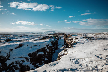 beautiful canyon in Iceland covered in snow with a blue sky and clouds