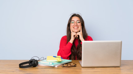 Teenager student girl studying in a table smiling with a happy and pleasant expression