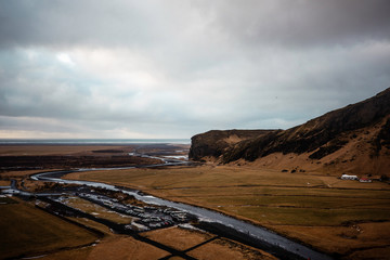 Obraz premium amazing view of part of Iceland with the mountain and ocean in the background on a cloudy day with buses and cars 