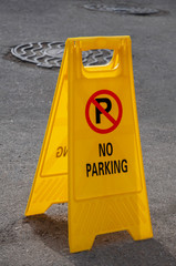 Yellow plastic sign prohibiting parking.