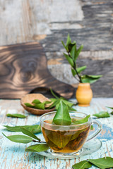 Fresh tea from bay leaf in a cup on a wooden rustic table. Copy space