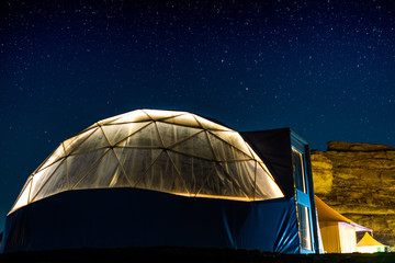 open tent in desert behind stars