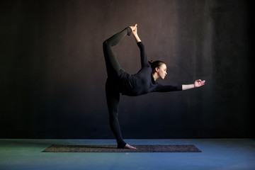 Woman practicing yoga, stretching in Natarajasana exercise