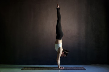 woman practicing yoga, Adho Mukha Vrksasana exercise, Downward facing Tree pose