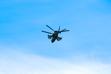 Fototapeta na wymiar Russian military combat attack helicopter K-52 Alligator flies against a blue sky and clouds
