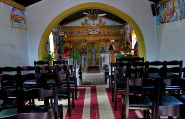 small church inside with icons and chairs in Europe