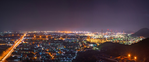 Fototapeta premium Aerial view of oil refinery near city at night.Panorama