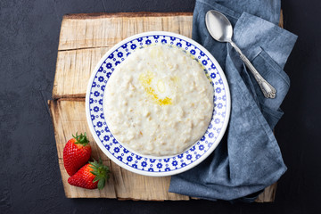 Oatmeal Porridge with Strawberries. Healthy Breakfast with Fresh Organic Berries. Flat lay with copy space.