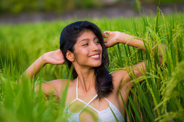 Naklejka na ściany i meble young happy and beautiful hispanic woman smiling playful having fun posing sexy isolated on green rice field in Asia tourist trip and Summer holidays travel and tourism