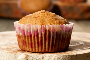 homemade muffins with coconut chips on a wooden stand