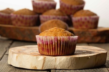 homemade muffins with coconut chips on a wooden stand