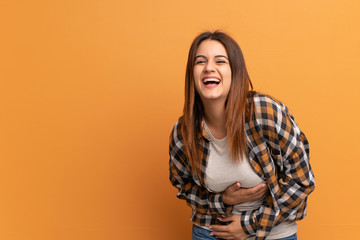 Young woman over brown wall smiling a lot