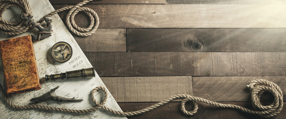 Vintage nautische reisinstrumenten met touw en anker op houten scheepsdekachtergrond - reis- / leiderschapsconcept