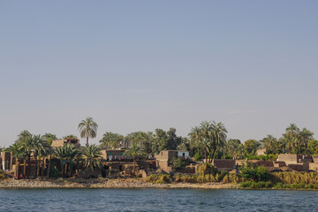 Nile River, Egypt: Houses and palm trees line the east bank of the Nile River.