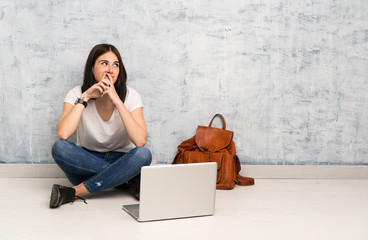 Student woman sitting on the floor scheming something
