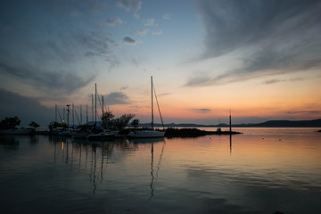 Sunset on lake Balaton, Hungary, which gives place to the blue ribbon international competition each year and also presented with the reflection of the humbling boats in the foreground.