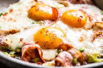 English breakfast fried bacon ham and eggs in ceramic pan