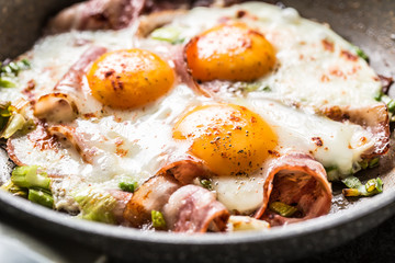 English breakfast fried bacon ham and eggs in ceramic pan