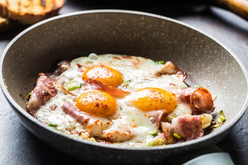 English breakfast fried bacon ham and eggs in ceramic pan