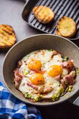 English breakfast fried bacon ham and eggs in ceramic pan