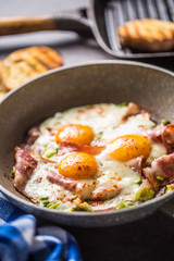 English breakfast fried bacon ham and eggs in ceramic pan