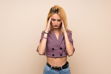 Fototapeta premium Young blonde woman with pink jacket over isolated wall with headache
