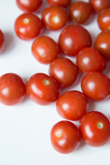 A handful of scattered tomatoes. Ripe cherry tomatoes on white background.