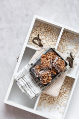buckwheat crispbread or puffed buckwheat with chocolate  on wooden vintage textural box on marble background with copy space