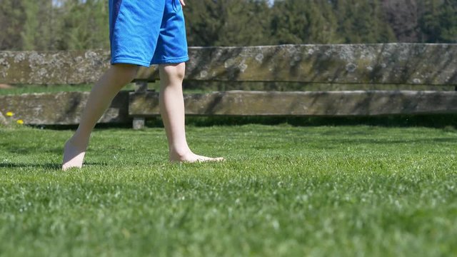 4k slow motion of young boy kicking a football