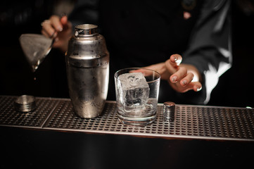 Fototapeta na wymiar Close shot of shaker and glass with ice