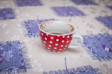 Obraz na płótnie Canvas Beautiful red with white tufts cup of coffee on table