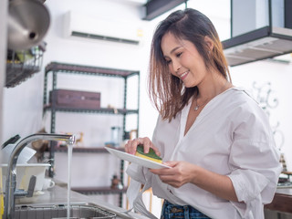 young happy asia housewife enjoy with her cleaning work at home or her coffee cafe