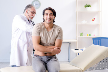 Obraz premium Young male patient visiting old doctor 