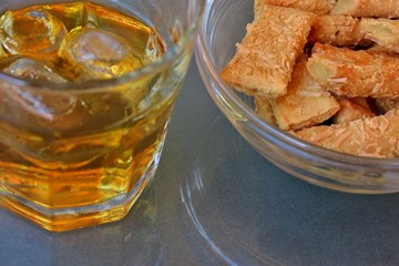 whiskey with ice and chopsticks with cheese for a snack