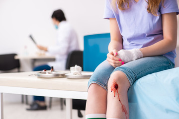 Obraz na płótnie Canvas Leg injured young woman visiting male doctor 