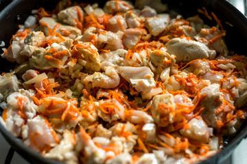 Cooking, sliced carrots and meat fried in a pan