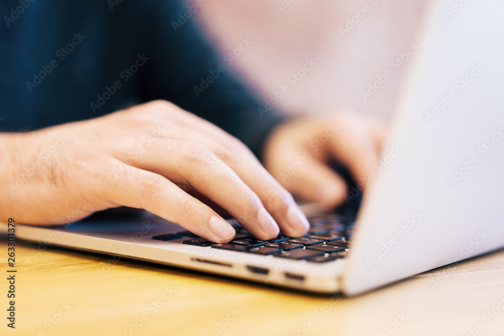 Poster sideview of man using laptop on desktop