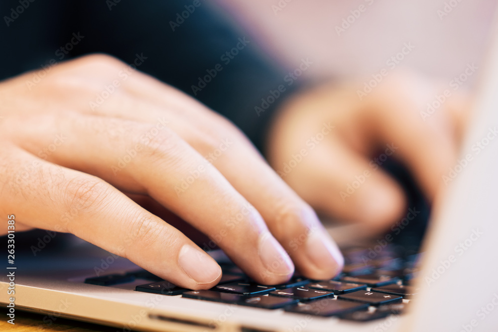 Poster sideview of man using laptop on desk top