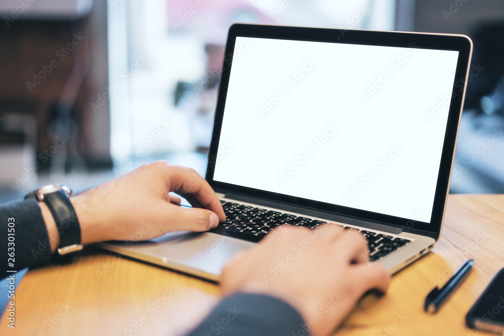 Poster man using white laptop screen on desktop