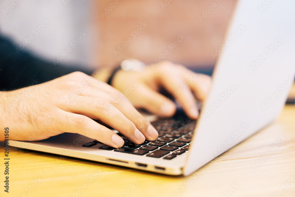 Poster sideview of businessman using laptop on desktop