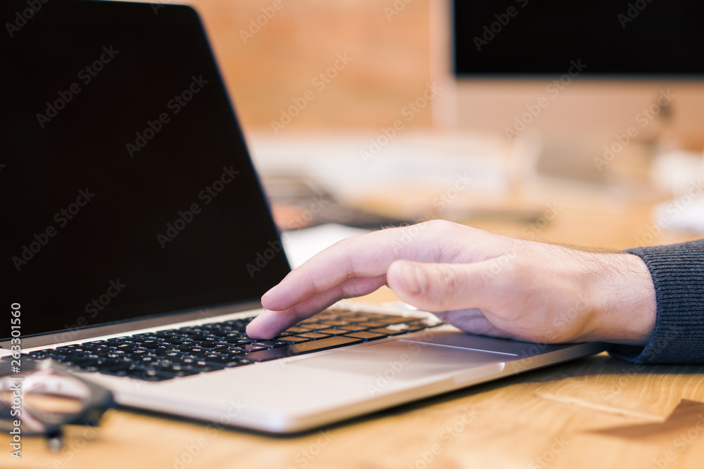 Poster man using blank laptop screen on desktop