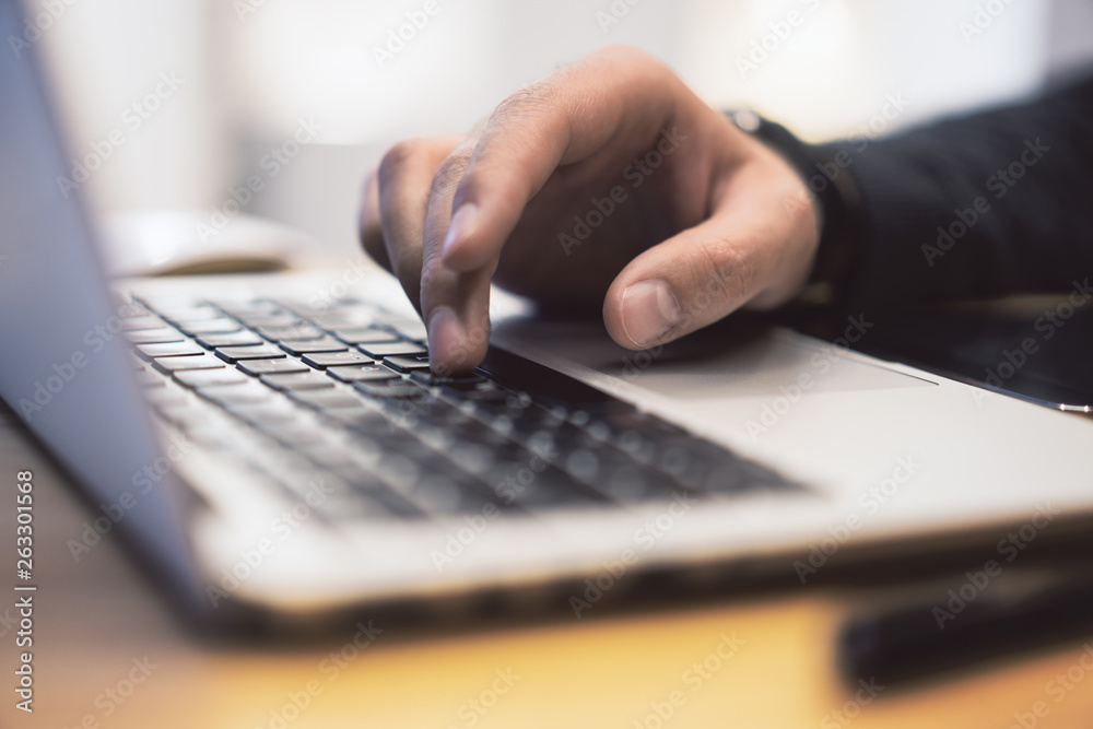 Poster sideview of man using notebook on desk