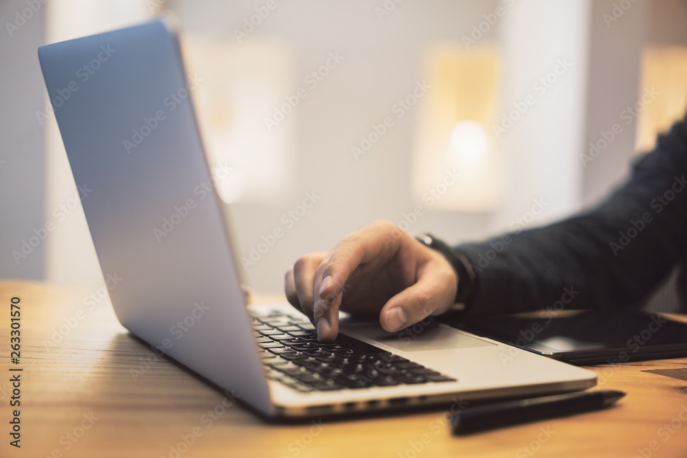 Poster sideview of man using notebook on desktop