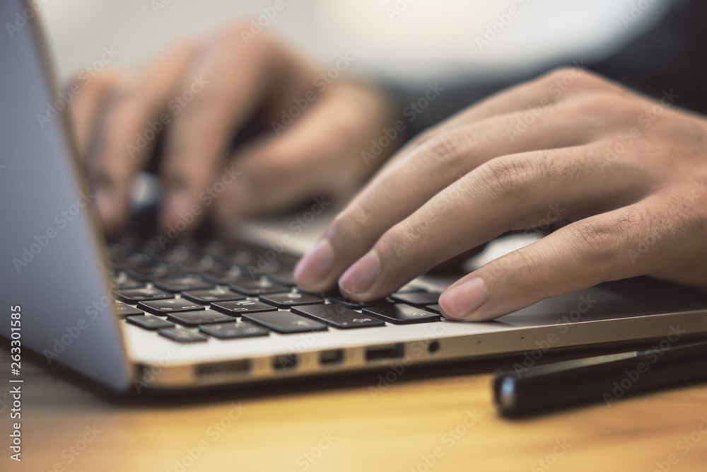 Poster sideview of man using notebook on table