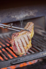 Beef ripe steaks on flaming charcoal grill