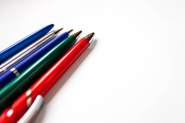 row selection of assorted multi colored ballpoint pens of different colors on light blue background. Back to school creativity concept. Selective focus, text copy space.