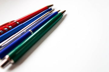 row selection of assorted multi colored ballpoint pens of different colors on light blue background. Back to school creativity concept. Selective focus, text copy space.